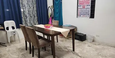 a dining room with a wooden table and chairs at Short Stay BF Resort in Manila