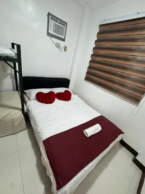 a bedroom with a bed with red pillows on it at 143 Private Resort in Trece Martires