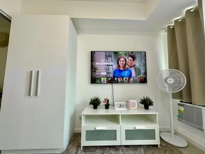 a living room with a tv on the wall at Casa Elisha Azure Urban Resort Staycation in Manila