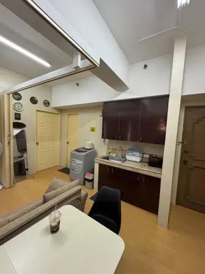 a kitchen and living room with a table and a couch at Greenhills commercial center 1-2BR condominium in Manila