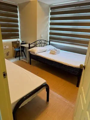 a small bedroom with a bed and a window at Greenhills commercial center 1-2BR condominium in Manila