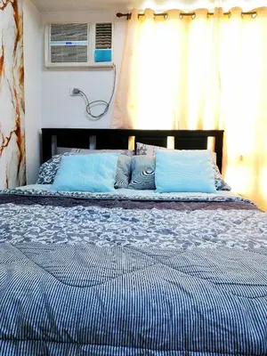 a bed with blue pillows in a bedroom at Studio Unit at The Beacon Makati in Manila