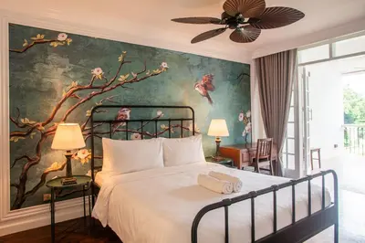 a bedroom with a bed with a painting on the wall at MIRANAMIN NEST Elegant Home, Indoor Plunge Pool, Pet-Friendly, with Rooftop, Kitchens, Self-Service Breakfast - Ideal for Reunions, Team Building, Intimate Gatherings in Manila
