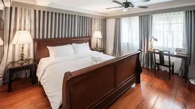 a large bedroom with a large bed and a desk at MiraNamin Nest LANTANA - Luxury Suite in Unique Historic Home with Garden Access, Indoor Plunge Pool, Self-Service Breakfast, Rooftop, Bathtub, Private Kitchen in Manila