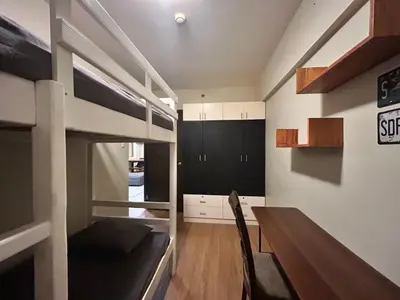 a room with a loft bed and a dining table at The Mindful Home - 2BR Cozy Condo near NAIA in Manila