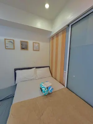 a bed in a room with a large window at Skyrest Staycation - Azure Urban Resort in Manila