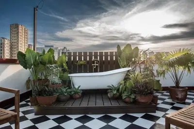 a bath tub sitting on a deck with plants at MiraNamin Nest GUMAMELA - Family Suite in Historic Home with Indoor Plunge Pool, Garden View, Pet-Friendly, Self-Service Breakfast in Manila