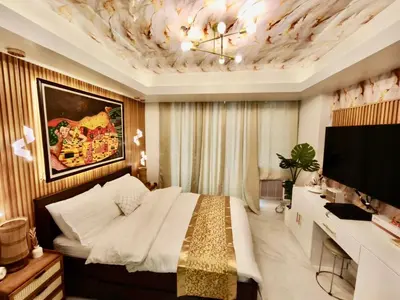 a bedroom with a bed and a desk and a television at Paris Hilton Beach Resort in Manila