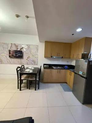 a small kitchen with a table and a refrigerator at 4kys staycation in Manila