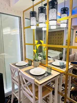 a dining room with a table with chairs and mirrors at We Vibe, Azure Urban Resort Residences in Manila