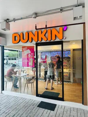 a dunkin donuts store with people standing in the window at We Vibe, Azure Urban Resort Residences in Manila