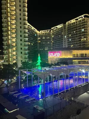 a large building with a christmas tree in front of it at Miami Suites in Manila