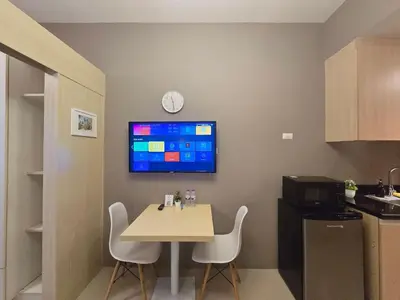 a small room with a table and a tv on the wall at 1BR Condotel with Balcony at SM Light Residences #LT13 in Manila
