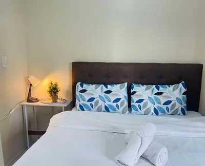 a bed with two white towels sitting on it at Jennie's Lucky 5M Suite in Manila
