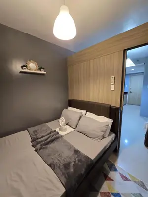a bedroom with a large bed with a lamp at Shore Residences Cozy oasis by Richnells Tower D in Manila