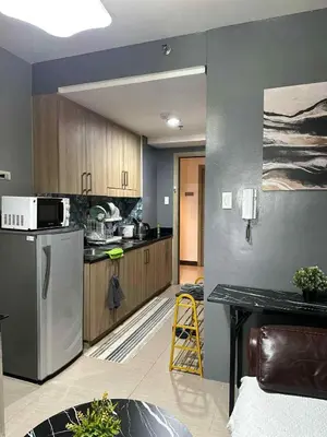 a kitchen with a stainless steel refrigerator and wooden cabinets at Shore Residences, Vintage charm by Richnells Tower D in Manila