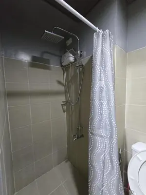 a bathroom with a shower with a white shower curtain at Shore Residences, Vintage charm by Richnells Tower D in Manila