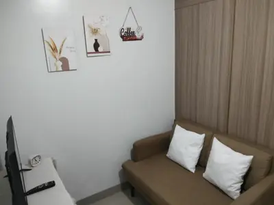 a room with a couch and some pictures on the wall at VSV Luxury Family suits Moa staycation in Manila