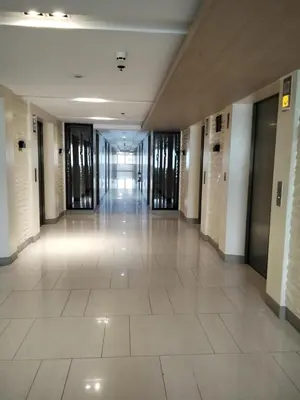 an empty hallway in a building with glass doors at VSV Luxury Family suits Moa staycation in Manila