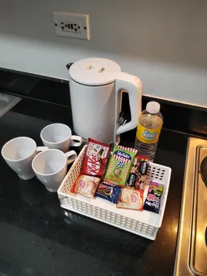 a counter with a tray of food and a coffee maker at VSV Luxury Family suits Moa staycation in Manila