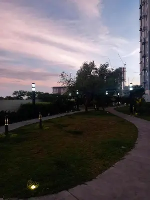 a park with a grassy area with trees and buildings at Spacious Staycation in Pasig Urban Metro Escape in Manila
