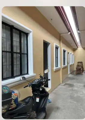 a scooter parked next to a building with windows at Laureano di trevi tower 2 Condominium Corporation in Manila
