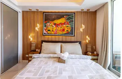 a bedroom with a large bed and a painting on the wall at Miami suites in Manila
