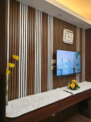 a room with a television and a table with flowers at 1 bedroom Cozy Escape in Manila