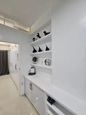 a white kitchen with black vases on shelves at White House Staycation by Trixie Datiles in Manila