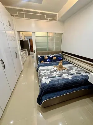 a bedroom with two beds with a teddy bear on it at White House Staycation by Trixie Datiles in Manila