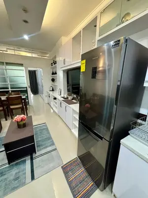 a kitchen with a stainless steel refrigerator and a table at White House Staycation by Trixie Datiles in Manila
