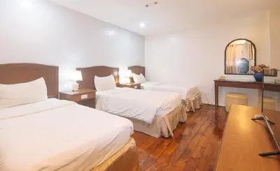a hotel room with two beds and a table at Comfy Inn Manila Kalaw by RedDoorz in Manila