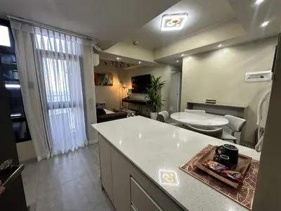 a kitchen and living room with a counter and a table at La nobleza terrazas condominium in Manila