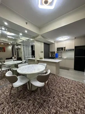 a large room with tables and chairs and a kitchen at La nobleza terrazas condominium in Manila