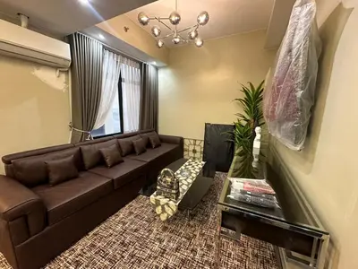 a living room with a brown couch and a window at La nobleza terrazas condominium in Manila