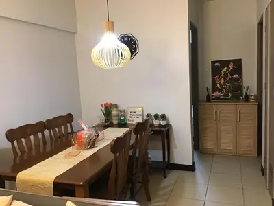 a dining room with a table and a chandelier at Alea Residences Condominium Casa Hayakawa in Manila