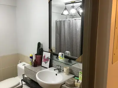 a bathroom with a sink and a toilet and a mirror at Alea Residences Condominium Casa Hayakawa in Manila