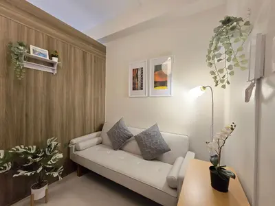 a living room with a white couch and some plants at 1BR Condotel with Balcony at FAME Residences #FM64 in Manila