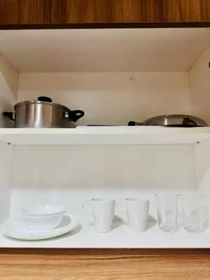 a shelf with cups and pots and pans on it at Claire's place in Manila