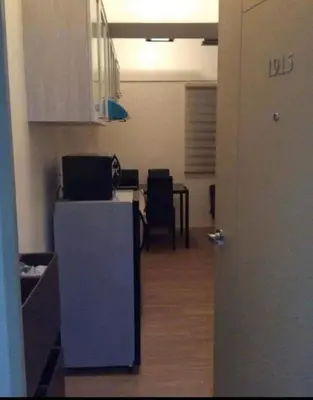 a room with a kitchen with a table and chairs at Laureano di trevi tower 2 Condominium Corporation in Manila
