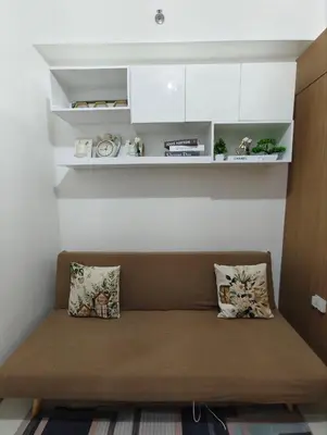 a couch in a room with white shelves at Stylish Condo with City View and Netflix - Pool Access in Manila