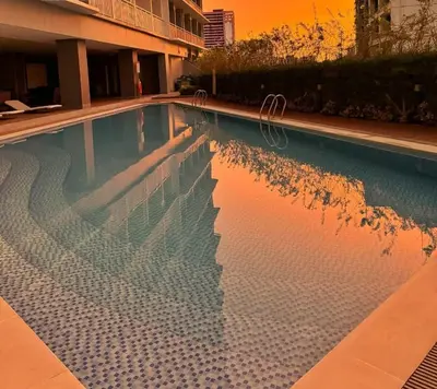 a swimming pool with a reflection of a building at Stylish Condo with City View and Netflix - Pool Access in Manila
