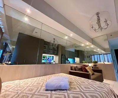 a bedroom with a bed and a living room at Modern Comfort Living! Netflix Ready in Manila