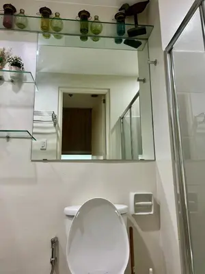 a bathroom with a white toilet and a mirror at Modern Comfort Living! Netflix Ready in Manila