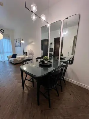 a dining room with a table with chairs and mirrors at Chelsea Tower 1 in Manila