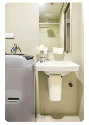 a white bathroom with a sink and a mirror at S-Residence Staycation Near IKEA,MOA,PICC in Manila
