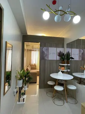 a living room with two tables and a couch at Field Residences Condominium in Manila