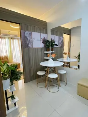 two tables and stools in a room with plants at Field Residences Condominium in Manila