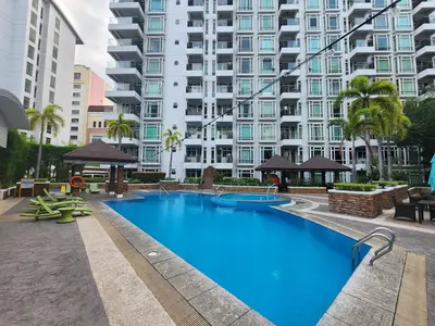 a large swimming pool in front of a large building at 1BR Condo w Balcony near NAIA, Casino, Newport in Manila