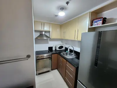 a small kitchen with a sink and a refrigerator at 1BR Condo w Balcony near NAIA, Casino, Newport in Manila